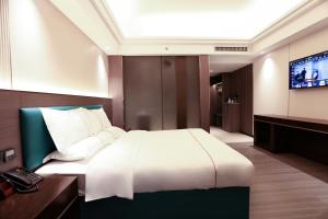 a bedroom with a large bed and a television at Mei Gang Hotel in Guangzhou