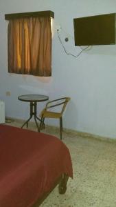 a room with a table and a chair and a television at San Diego Tu Casa in Campeche