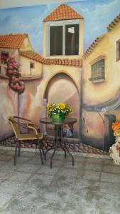a table in front of a wall with a vase of flowers at San Diego Tu Casa in Campeche