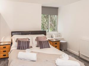 a bedroom with a large bed with towels on it at 3 Mount Pleasant-uk36650 in Looe