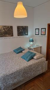 ein Schlafzimmer mit einem Bett mit zwei blauen Kissen in der Unterkunft Appartamento Alla Salute in Venedig