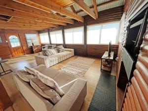 ein Wohnzimmer mit einem Sofa und einem TV in der Unterkunft Jeffreysbay charming wooden house close to beach in Jeffreys Bay