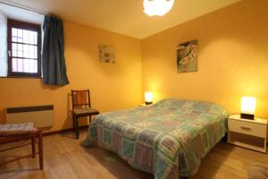 - une chambre avec un lit, une chaise et deux lampes dans l'établissement Sagette, à Laruns