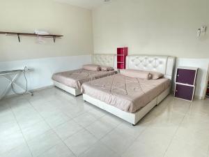 two beds sitting in a room with at Kuza Homes Batu Berendam in Melaka