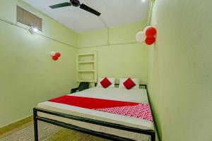 a bedroom with a bed with red sheets and balloons at Flagship The Moon Palace in Patna
