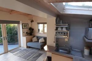 a kitchen with a sink and a couch in a room at Cosy Cabin near Lough Hyne in Skibbereen