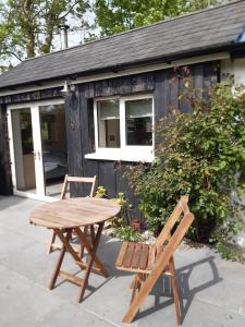 a picnic table and two chairs in front of a shed at Cosy Cabin near Lough Hyne in Skibbereen +6 photos