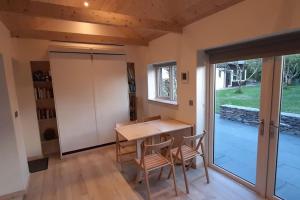 a dining room with a table and chairs and a sliding glass door at Cosy Cabin near Lough Hyne in Skibbereen
