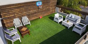 a backyard with chairs and a fence and grass at Villa Rosen at Ramat Hahayal TLV in Tel Aviv