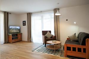 sala de estar con sofá y TV en Fewo Gretchen, en Mittenwald