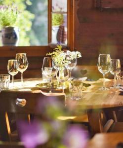 a table with wine glasses and flowers on it at Alphotel & Bergrestaurant Sankt Martin 