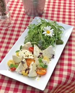 a plate of food with a salad on a table at Alphotel & Bergrestaurant Sankt Martin 