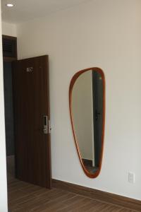 a mirror on a wall next to a door at AN PHÚ Home in Da Lat