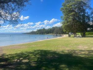 einen Strand mit Menschen, die im Wasser schwimmen in der Unterkunft Poppies Lakeview Terrace - 2 Bedroom in Cams Wharf