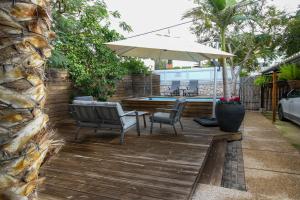 a patio with chairs and an umbrella and a pool at Villa Rosen at Ramat Hahayal TLV in Tel Aviv