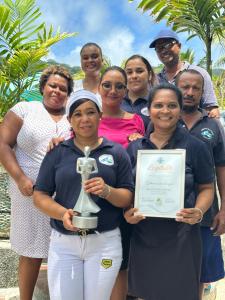 un grupo de personas posando para una foto con un trofeo en Cabanes Des Anges, en La Digue