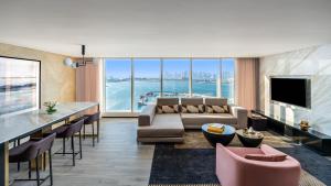ein Wohnzimmer mit Sofa und Bar in der Unterkunft Rixos Gulf Hotel Doha in Doha