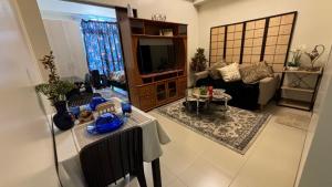 uma sala de estar com um sofá e uma televisão em Saint Honore Condominium em Iloilo