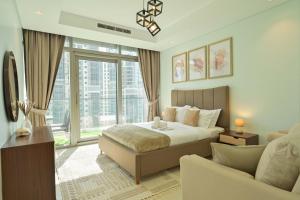a bedroom with a large bed and a couch at Burj Khalifa Views 2BR with Infinity Pool Downtown in Dubai