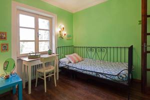 a bedroom with a bed and a desk and a window at Cottage a Bossolasco con piscina in Niella Belbo +69 photos