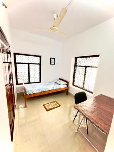 uma sala de estar com uma cama e uma mesa em Malgudi House - Commandant em Mysore