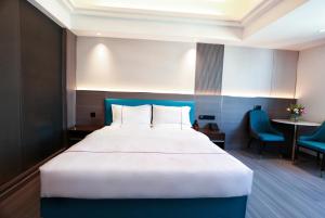 Postel nebo postele na pokoji v ubytování Mei Gang Hotel
