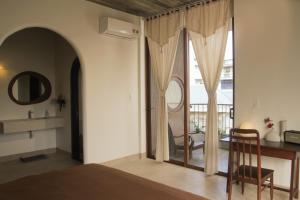 a bedroom with a bed and a table and a mirror at Komi House Homestay in Hue