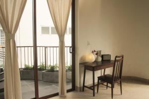 Habitación con mesa, silla y balcón. en Komi Homestay en Hue
