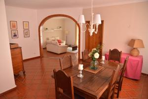 a dining room with a table and a couch at Break Holidays House in Moura