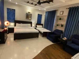 - une chambre avec un lit, un canapé et une chaise dans l'établissement Harveys Guest House, à Islamabad