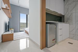 a kitchen with a refrigerator and a bedroom at Chic Urban Retreat Immerse Yourself In Comfort in Dubai