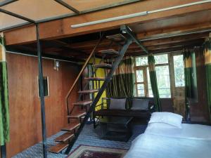 een slaapkamer met een bed en een trap in een kamer bij Jungle Crown Organic Homestay in Nagarkot
