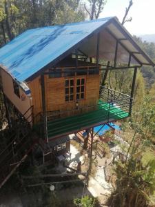 dom z niebieską plandeką na górze w obiekcie Jungle Crown Organic Homestay w mieście Nagarkot