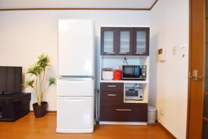 een keuken met een koelkast en een magnetron bij OMOTENASHI in Kyoto