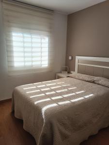 - une chambre avec un grand lit et une fenêtre dans l'établissement Noemar, à Platja d'Aro