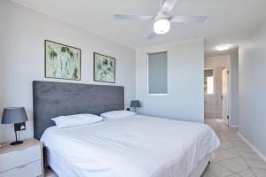 - une chambre avec un lit blanc et un ventilateur de plafond dans l'établissement Chakas Cove 95, à Ballito