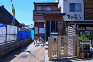 een huis met een hek en een fiets geparkeerd buiten bij OMOTENASHI in Kyoto