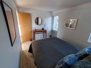 Schlafzimmer mit einem Bett, einem Tisch und einem Fenster in der Unterkunft Cozy Summerhouse With Spectacular Views! in Ølsted