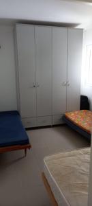 a bedroom with white cabinets and a bed at משפחתית בשובה 