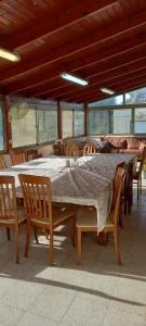 een grote tafel en stoelen in een kamer bij משפחתית בשובה 
