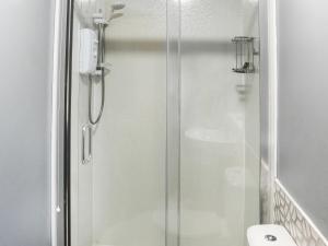 a shower with a glass door in a bathroom at Bryn Poeth in Bodorgan