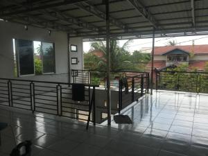 a balcony of a house with a table and railing at Orion Jaya Kost in Ketapang
