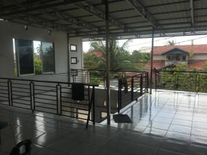 a balcony of a house with a table and railing at Orion Jaya House in Ketapang
