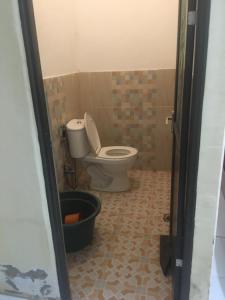 a bathroom with a toilet and a bucket at Orion Jaya House in Ketapang