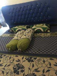 a bed with a blue headboard and pillows on it at Orion Jaya Kost in Ketapang