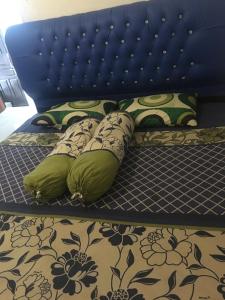 a bed with a blue headboard and pillows on it at Orion Jaya House in Ketapang