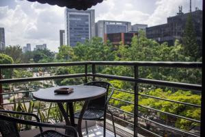 a table and chairs on a balcony with a view of a city at Hotel Bambu Milla De Oro in Medellín