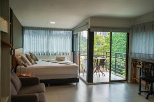 a bedroom with a bed and a balcony at Hotel Bambu Milla De Oro in Medellín