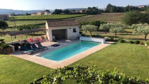 a swimming pool in the yard of a house at Les Oliviers De Notre Dame in Mazan +10 photos