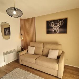 una sala de estar con sofá y una foto de un ciervo en Le Montagnard, en Mijoux